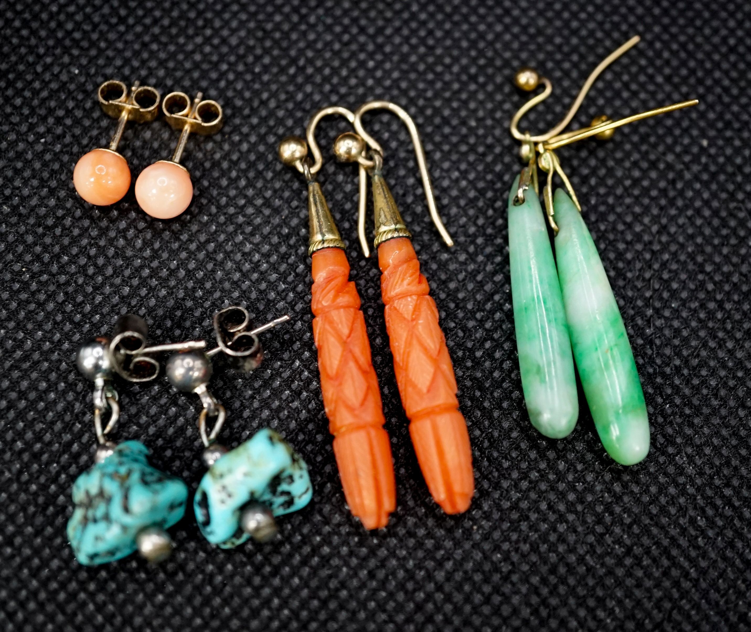 A pair of gilt metal and carved coral set teardrop shaped earrings, 38mm, a pair of similar shaped jade earrings and two other pairs of ear studs.